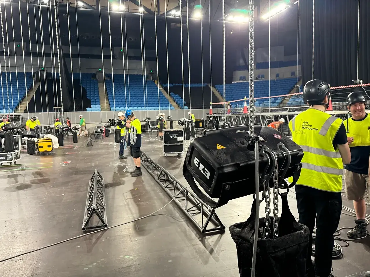 Crew working under a chain hoist during a load-in at a working venue