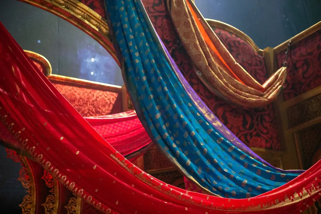Close-up of deep red Moulin Rouge stage drapes with festoon lights hanging in front. Photo: Chris Parker.